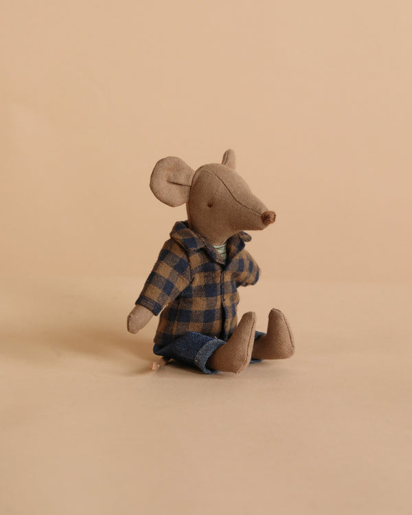 The Maileg Dad Mouse - Light Brown is a small, soft cotton mouse wearing a blue and brown plaid shirt and blue pants, sitting upright on a plain beige surface with a matching beige background.