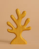 The Handmade Holzwald Yellow Coral is a simple, stylized wooden figurine with multiple rounded branches painted yellow, standing upright against a light beige background.