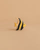 The Handmade Holzwald Moorish Idol Fish is a small, hand-painted wooden toy with yellow and black stripes, displayed on a beige surface—an enchanting piece for any collection of educational wooden toys.