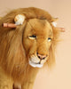 A close-up of a Stuffed Animal Lion Rocker with expressive eyes and a majestic mane, featuring noticeable detailing around the muzzle and ears. This artisan crafted toy showcases exceptional craftsmanship ideal for unique gifts.