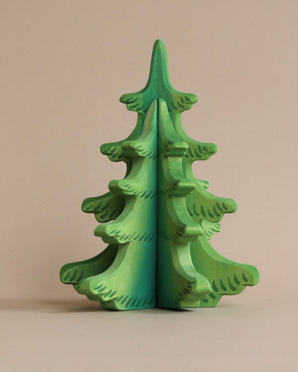 A handmade, three-dimensional puzzle shaped like a Extra Large Wooden Sugar Pine Tree, painted in different shades of green with non-toxic paint against a beige background.
