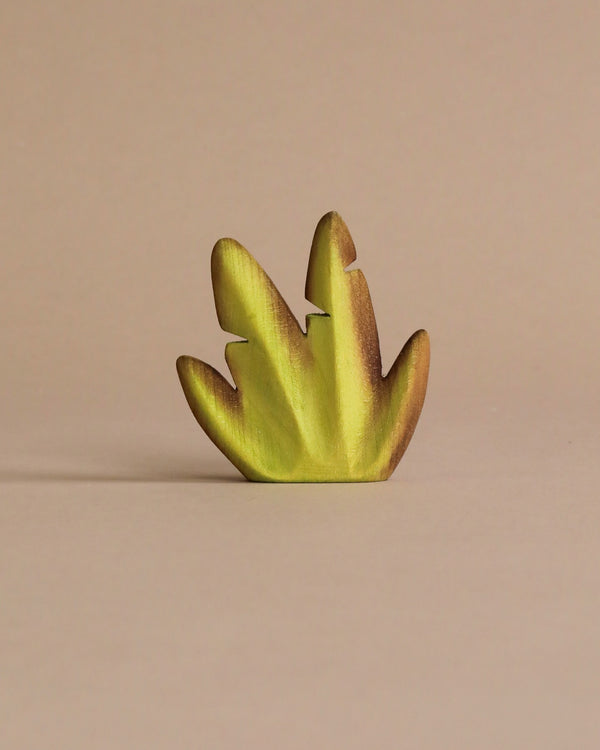 A small, metallic gold dinosaur toy, crafted from Wooden Banana Bush in a unique, abstract style, placed against a plain beige background.