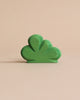 A vibrant green, three-dimensional Wooden Large Green Bush sculpture, crafted with non-toxic paint, displayed against a soft beige background, highlighting its smooth texture and artistic curves.