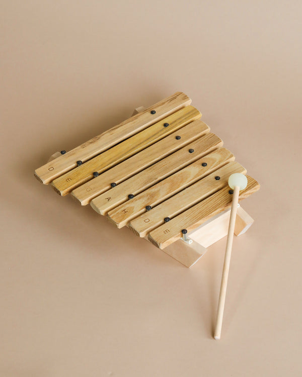 An Auris Xylophone XRP-007 - Pentatonic 7 tones with a white mallet on a beige background.
