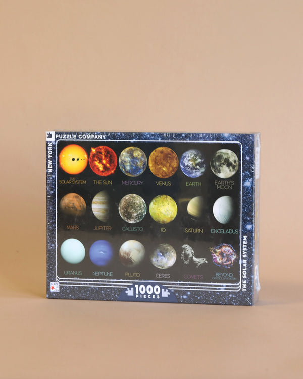 A NASA, The Solar System - 1000 Pieces puzzle from puzzle company featuring planets, moons, and celestial bodies of our solar system displayed against an orange background.