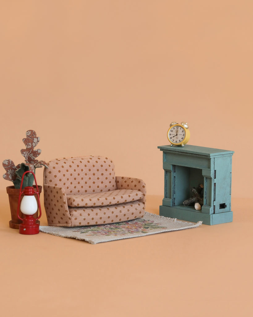 The Maileg Family Room Set features a polka-dot armchair, sofa bed, potted plant, red lantern, small rug, blue fireplace, and yellow clock—ideal mouse dollhouse furniture displayed on a plain beige background.