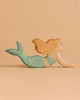 The Handmade Holzwald Mermaid Set features a wooden mermaid figurine with a teal tail and long, wavy, light brown hair, displayed on a plain beige background.