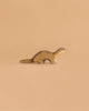 The Handmade Holzwald Otter is a small, handmade wooden animal figurine with a smooth finish and simple painted features, resting against a solid light brown background and capturing the charming style of Holzwald wooden toys.
