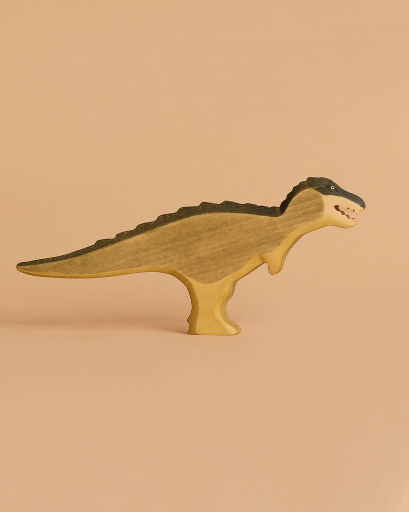 The Handmade Holzwald Dinosaur Set features upright wooden dinosaur toys painted in brown and black, set against a beige backdrop—an ideal example of sustainable craftsmanship.