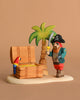 The Bumbu Handmade Wooden Treasure Hunt Set includes a pirate with a sword, palm tree, open gold-filled chest, and colorful parrot—perfect for Montessori-inspired adventures.