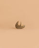 The Handmade Holzwald Small Sloth, a small wooden toy with a simple design, lies on its back against a plain light beige background—a delightful addition to any sustainable toy collection.