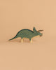 Part of the Handmade Holzwald Dinosaur Set, this blue and cream wooden triceratops stands on a beige background—ideal for lovers of sustainable wooden toys.