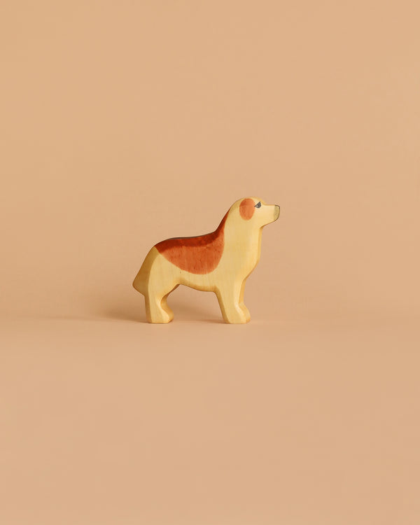 The Handmade Holzwald Golden Retriever is a small, wooden dog figurine in brown and beige hues, displayed on a light brown background—ideal for fans of sustainable toys.