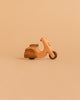 The Handmade Wooden Scooter, crafted from beech wood with smooth, simple edges, sits on a neutral beige background.
