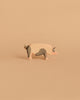 The Ostheimer Spotted Pig - Head High, a handcrafted wooden toy with gray patches, stands on a beige background—perfect for imaginative play and inspired by classic Ostheimer quality.