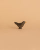 The Handmade Holzwald Blackbird is a small, dark wooden bird figurine with a yellow beak on a light beige background—ideal for imaginative play and a charming, eco-friendly addition to any sustainable toy collection.