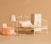 Maileg Bedroom Set featuring delightful Maileg mouse furniture, including a vintage-inspired white metal bed with patterned bedding, a small wardrobe, pink armchair, lamp, and rug—all beautifully displayed on a beige background.