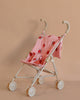 The Konges Sloejd Doll Stroller - Ladybug stands out against a beige background with its delightful ladybug design, white double wheels, handles, and easily removable fabric for cleaning.