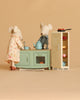 Grandma and Grandpa Maileg mice stand beside their Maileg Kitchen Set, which includes a metal fridge stocked with food and a stove with a pan. The scene is set against a solid beige background.