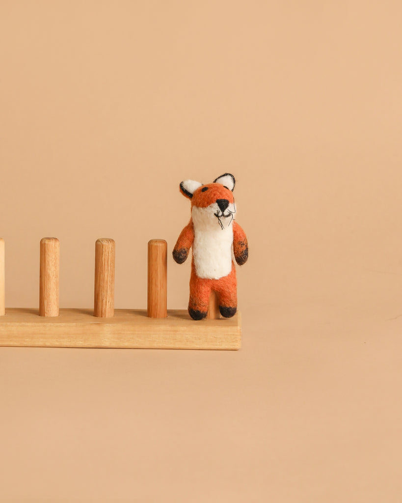 The Felt Finger Puppet: Fox stands on a wooden peg board against a plain beige background, perfect for imaginative storytelling.