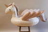 Inflatable Unicorn Float in a cream color, with handles on the neck, displayed on a wooden stool against a neutral backdrop.