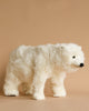 A fluffy white bear-shaped **Polar Bear Cub Stuffed Animal** with a realistic furry texture, black eyes, and nose, positioned against a plain beige background.