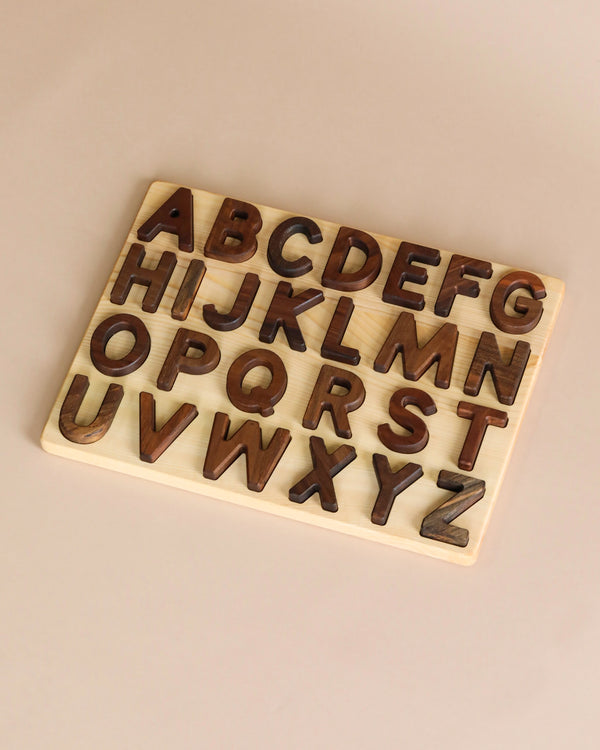 Uppercase Walnut Alphabet Puzzle board with alphabetical letters A to Z arranged in rows, displayed on a plain background. Each letter fits into its respective shaped slot on the board.