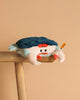 A Steiff Curby Crab Plush Stuffed Toy, 9 inches, in blue and white with orange claws and a tag, sits on the edge of a wooden stool against a plain beige background.