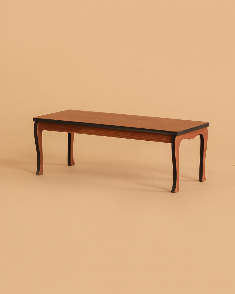 A rectangular wooden coffee table with curved legs, set against a plain beige background, makes the perfect display for the Maileg Family Celebration Set or can be paired charmingly with a Maileg mouse set.