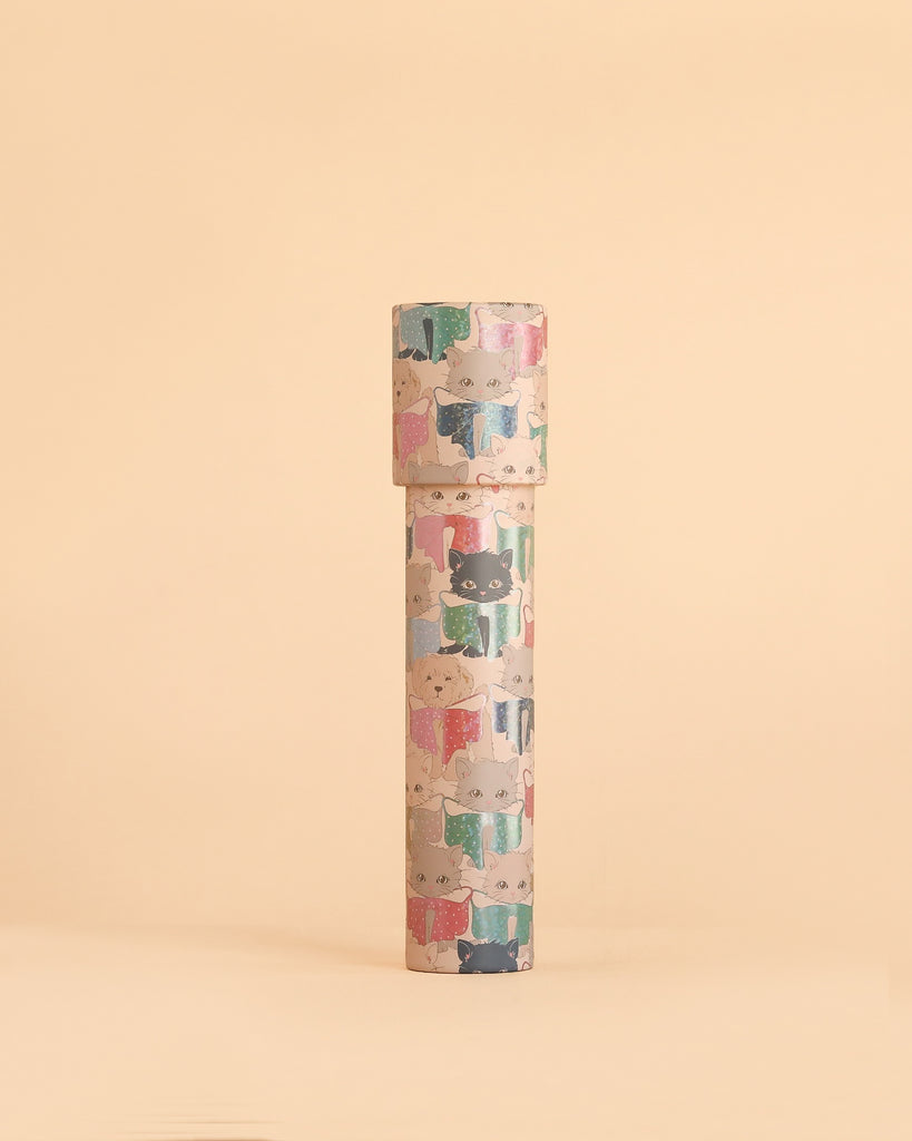 The Konges Sloejd Kaleidoscope - Like Cats and Dogs is a tall cylindrical container crafted from FSC-certified cardboard, featuring whimsical cartoon cats in sweaters and displayed upright against a plain beige background.