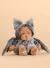 The Bukowski - Bear In Bat Costume features a plush teddy bear dressed in a gray bat outfit with large ears and wings, ideal for nighttime cuddles, and is pictured against a plain beige background.
