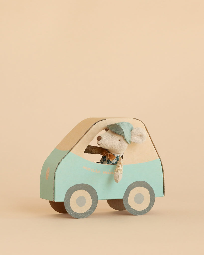 A Maileg Little Brother Driver Set, featuring a mouse wearing a cap, is displayed inside a light blue and beige cardboard car against a plain beige background.