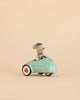 A Maileg Little Brother Driver Set features a small mouse wearing a blue cap and vest, sitting in a light blue toy car with white and orange wheels against a plain beige background.