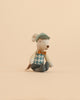 The Maileg Driver Mouse, Little Brother plush toy—dressed in a green cap, argyle vest, orange bow tie, and blue pants—sits upright on a beige background.