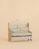 A Maileg Cozy Corner Set, featuring a small vintage-style bench with a scalloped backrest and a floral-patterned cushion, sits against a plain beige background.