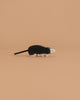 The Holztiger Mole, a handcrafted wooden figurine with black and white details, highlights the charm of HOLZTIGER European toys, shown against a plain beige background.