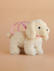 The Konges Sloejd Puppy Bag - Off White is a plush cream-colored dog toy with floppy ears, black eyes, and a pink harness that also serves as an adorable puppy-shaped bag.