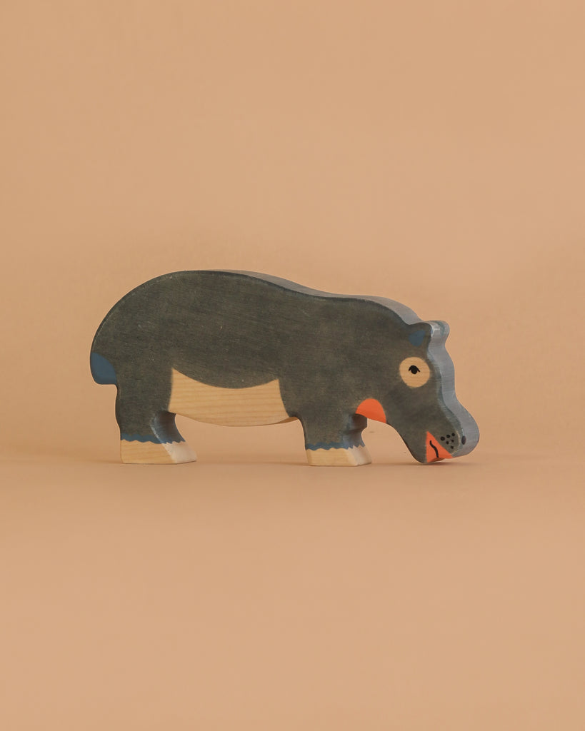 The Holztiger Handmade Wooden Safari Animals Set features a handcrafted hippopotamus toy made from maple and beech wood, painted in dark gray, white, and orange, shown against a plain beige background.