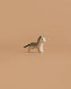 The Holztiger Cat, Small is a wooden figurine with painted gray stripes, green eyes, and a brown tail, shown standing on a plain beige background.
