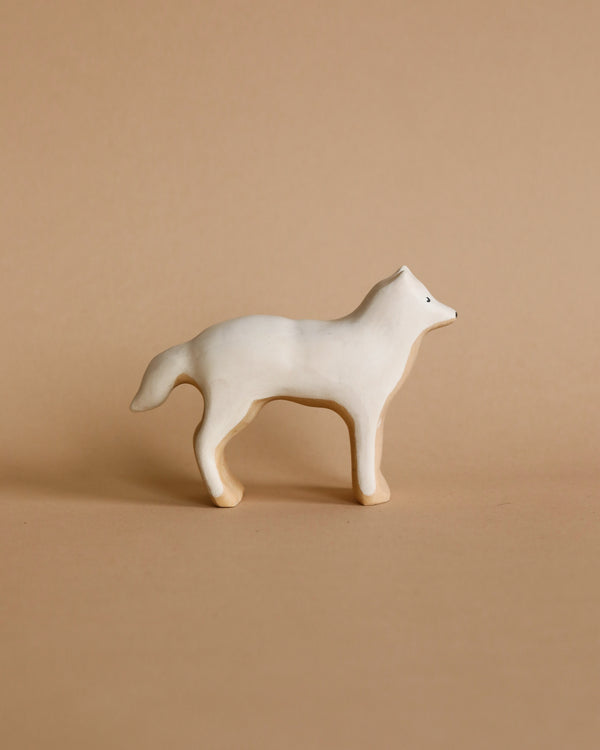 A small, minimalist Handmade Wooden Arctic Wolf stands against a plain beige background. The wolf is styled simplistically with smooth, rounded edges and a non-toxic, child-safe matte finish.