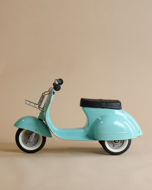 A light blue PRIMO Ride On Kids Toy Classic, showcasing a classic design, stands against a plain beige background, displaying its side profile with visible details like handlebars and wheel rims.
