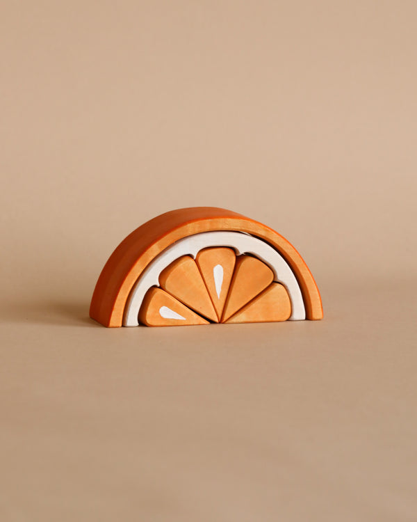 A Wooden Tangerine Stacking Toy painted in shades of orange, designed with semi-circular arches fitting neatly inside each other on a plain beige background, serves as an educational tool.