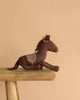 The Easter Basket Gift Set features a brown plush toy horse with a patterned saddle on a rustic wooden bench, perfect for adventures with the Maileg Cowboy Mouse against a plain beige background.