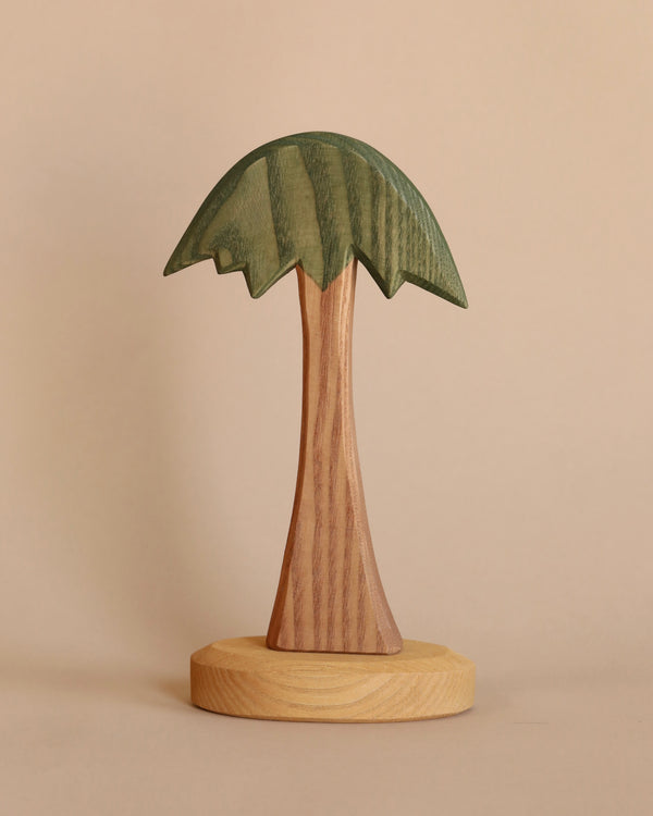 A handcrafted Ostheimer palm tree sculpture with detailed leaves and trunk, set against a plain beige background.