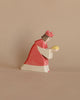 A handcrafted Ostheimer Red King With Crown, holding a golden orb, set against a plain beige background. The figure is stylized with simple, smooth shapes and muted tones.