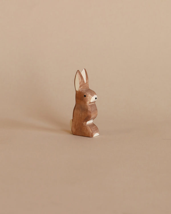 A Ostheimer Rabbit - Ears Up standing upright, part of the Ostheimer toys collection, placed against a plain beige background. The figurine is characterized by smooth lines and natural wood grain.