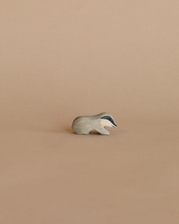 A small, minimalist Ostheimer Badger figurine on a plain beige background.