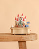 A Christmas Castle Music Box featuring a castle with red turrets, a Christmas tree, a reindeer, and a blue sleigh.