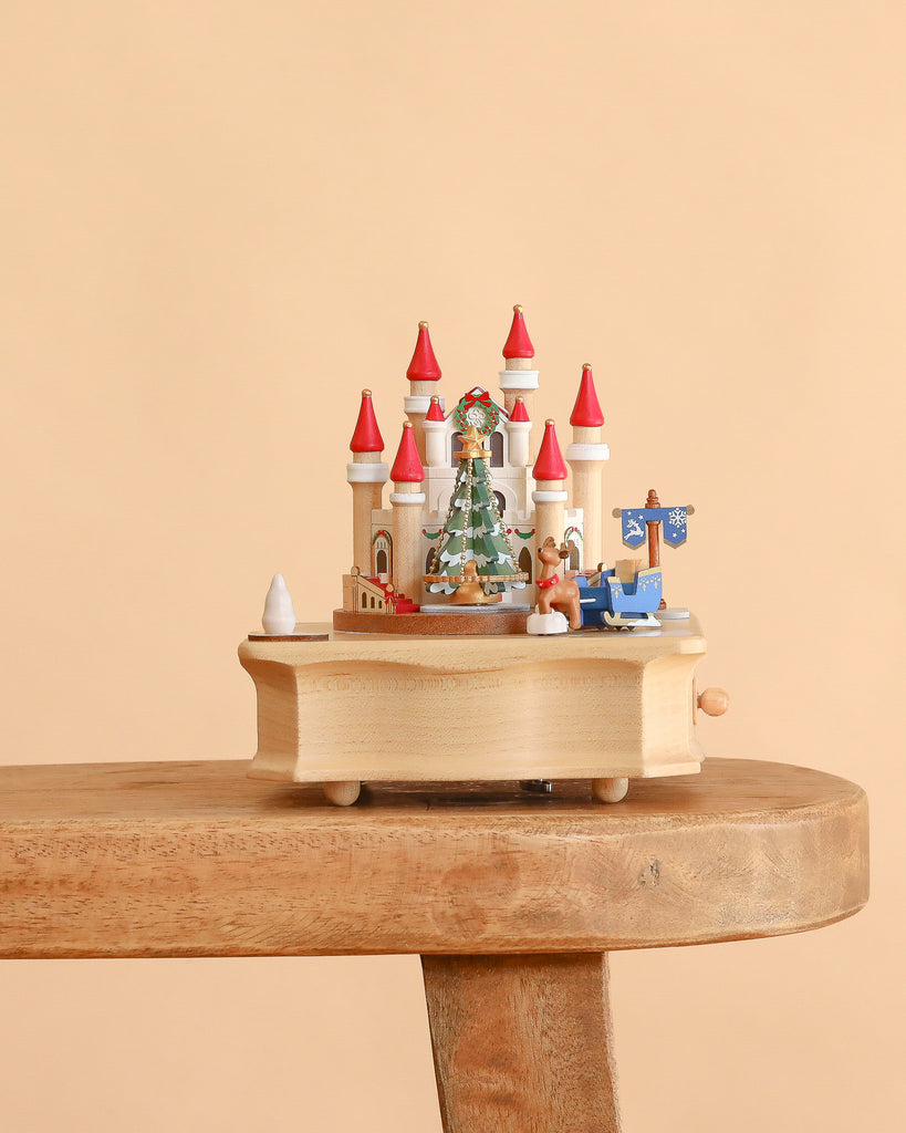 A Christmas Castle Music Box featuring a castle with red turrets, a Christmas tree, a reindeer, and a blue sleigh.