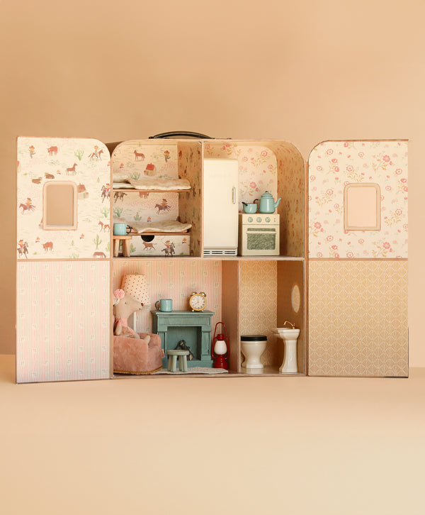 The open Maileg Suitcasa Furnished Set reveals rooms with a bed, kitchen appliances, a miniature armchair with a Maileg mouse, a fireplace, and bathroom fixtures.
